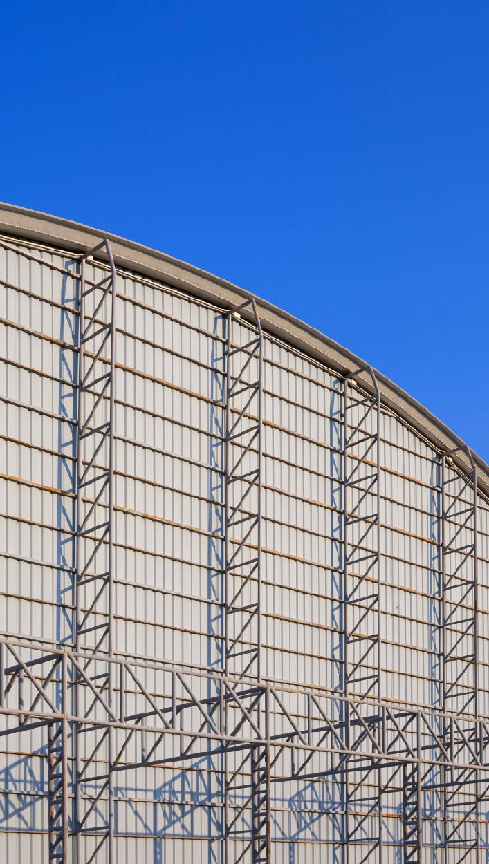 industrial-warehouse-building-with-curve-roof-metal-truss-structure-steel-wall-blue-sky (1)-01 Íves tetős acélcsarnok homlokzata